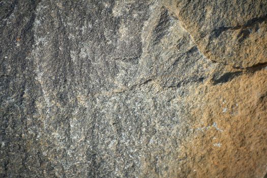 Background texture of old chipped natural stone close-up. Selective focus