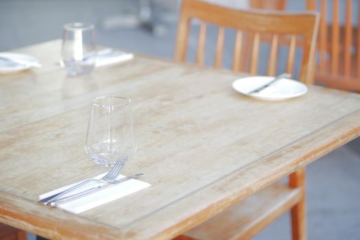 cutlery and empty plate on table against cafe background .