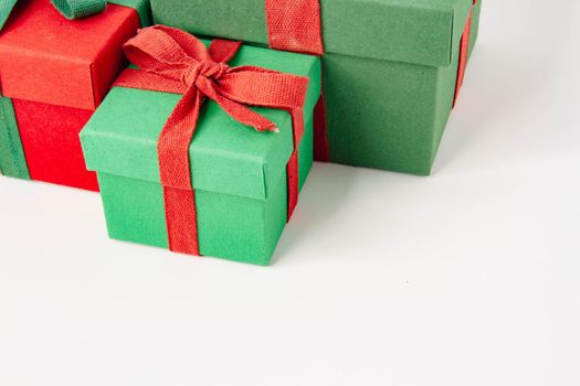 Present. Gift box with a bow. New Year's surprise. Red and green box with a gift. On a white background, top view. Close-up. Tied with a beautiful ribbon for gifting. Under the tree.