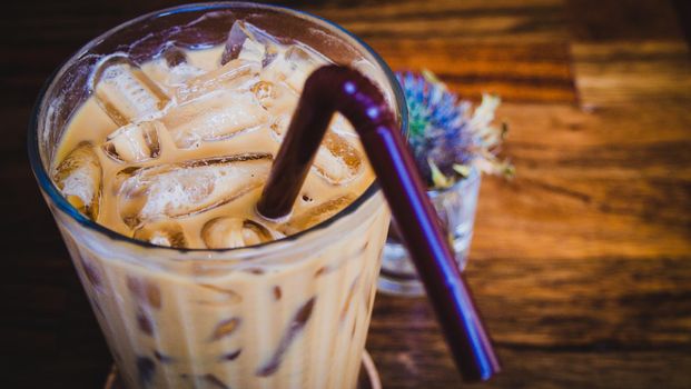iced latte coffee in a glass with cream on bottom . cold summer drink background