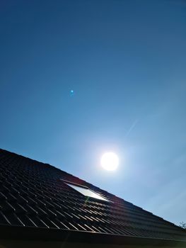 Open roof window in velux style with black roof tiles