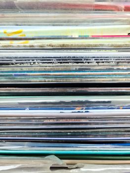 Numerous vintage signs and vinyl records in a box seen from above