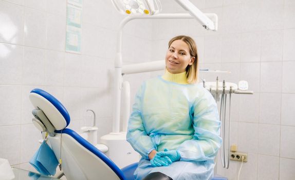 a female dentist sits in her dental office after work.