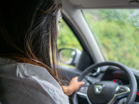 Beautiful business lady driving her car a cloudy day in summertime