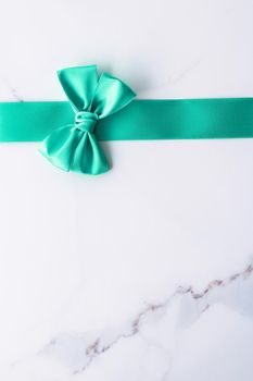 Holiday design, greeting card and vintage gift concept - Green silk ribbon on marble background, top view