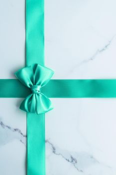 Holiday design, greeting card and vintage gift concept - Green silk ribbon on marble background, top view