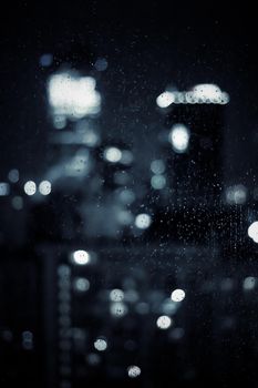 Big metropolitan city lights at night, blurry background - night life, abstract background and modern dark tones concept