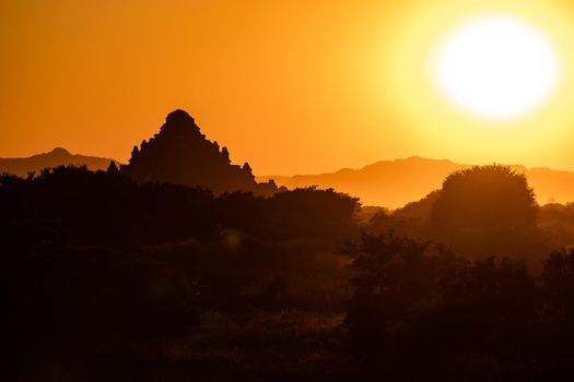 The landscape of the temples of Bagan in Myanmar bathed in yellow at sunset
