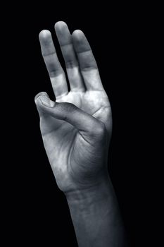 Shot of male hands demonstrating the Bhudy Yoga Mudra. Bhudy Yoga Mudra with pinky touched to thumb forming the mudra isolated on a black colored background. Vertical shot.