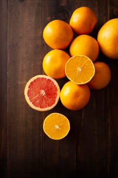 top view image of oranges and grapefruit on rustic wooden table