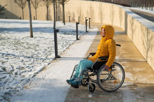 Woman in wheelchair relaxing in winter park