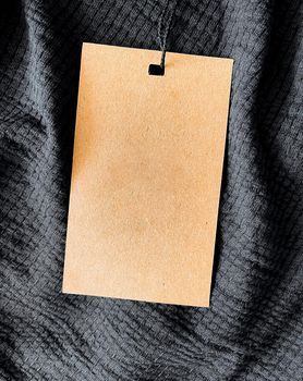 Blank fashion label tag, sale price card on luxury fabric background, shopping and retail concept