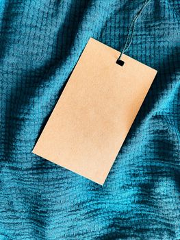 Blank fashion label tag, sale price card on luxury fabric background, shopping and retail concept