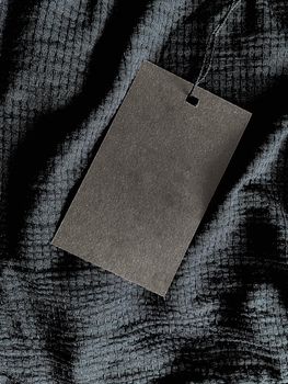 Blank fashion label tag, sale price card on luxury fabric background, shopping and retail concept