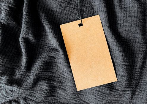 Blank fashion label tag, sale price card on luxury fabric background, shopping and retail concept