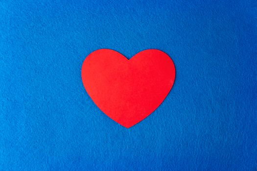 Paper cut red heart shape on blue textured background with copy space. Concept image. Valentine's day, mother's day, birthday greeting cards, invitation, celebration