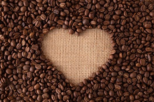 love concept image of heart shape frame made of coffee beans on burlap background