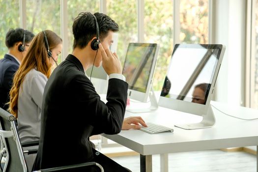 Young man with suit work as operator of the company with different action such as touch headphone or typing.
