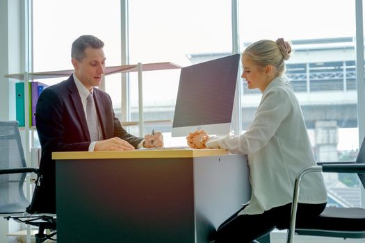 Beautiful blond hair girl talk with the business man for job interview.