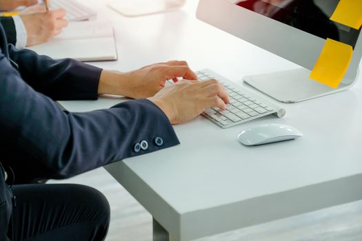 Hands of business man types some data or information to computer during working.