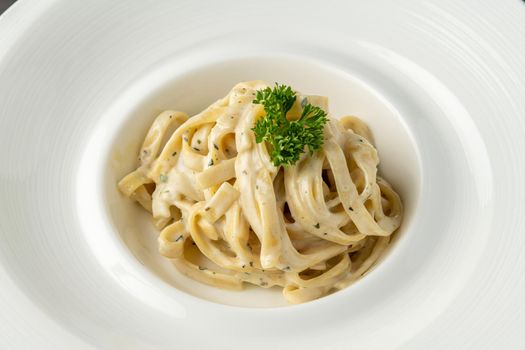 Freshly made fettucini alfredo on a white porcelain plate