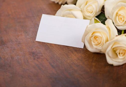 bouquet of white rose with green leaves on a wooden