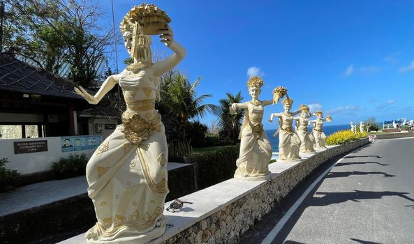 Bali, Indonesia - 06 July 2022: Sculpture of Balinese dancers at the entrance to Pantai Melasti Beach under the blue sky