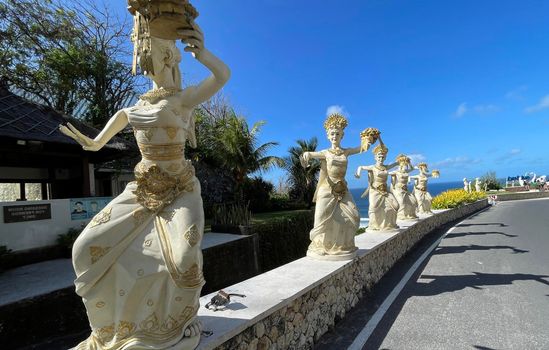 Bali, Indonesia - 06 July 2022: Sculpture of Balinese dancers at the entrance to Pantai Melasti Beach under the blue sky