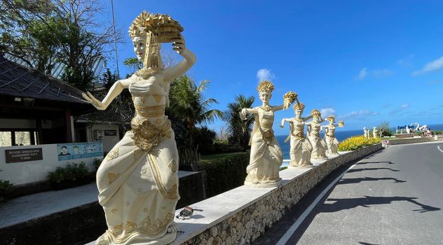 Bali, Indonesia - 06 July 2022: Sculpture of Balinese dancers at the entrance to Pantai Melasti Beach under the blue sky