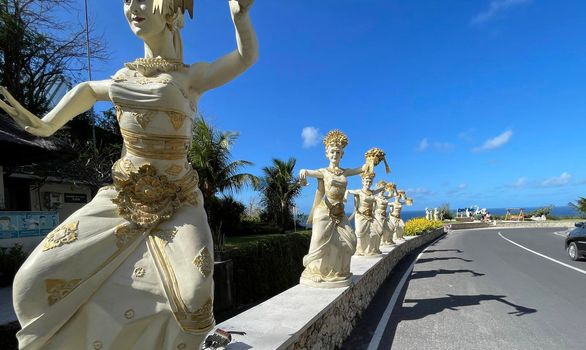 Bali, Indonesia - 06 July 2022: Sculpture of Balinese dancers at the entrance to Pantai Melasti Beach under the blue sky