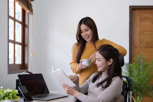 two friends talking and smiling one to each other in small break of studying with cup of coffee in hands.