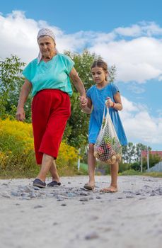 Child and grandmother carry vegetables in a bag. Selective focus. Food.