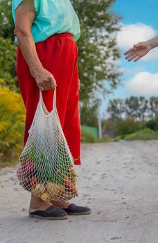 Child and grandmother carry vegetables in a bag. Selective focus. Food.