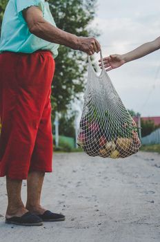 Child and grandmother carry vegetables in a bag. Selective focus. Food.