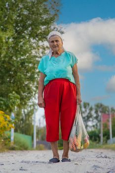 Grandmother carries vegetables in a shopping bag. Selective focus. Food.