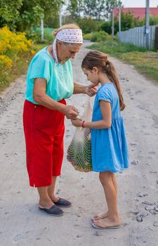 Child and grandmother carry vegetables in a bag. Selective focus. Food.