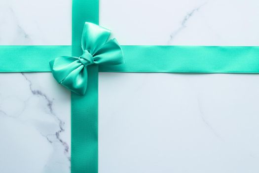 Holiday design, greeting card and vintage gift concept - Green silk ribbon on marble background, top view