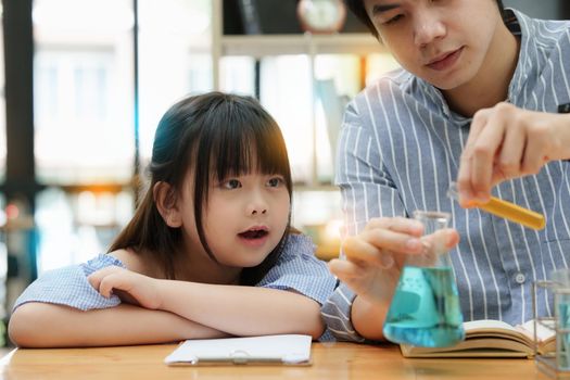 Girls and father doing science experiments. Education science concept.
