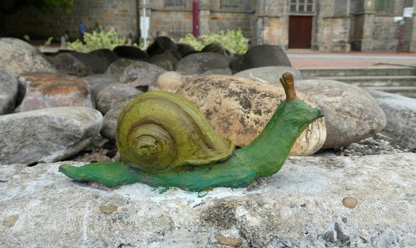 Uelsen, Germany - Aug 15 2022 Cute painted green snail. This snail is part of a statue at a fountain in the middle of this village.