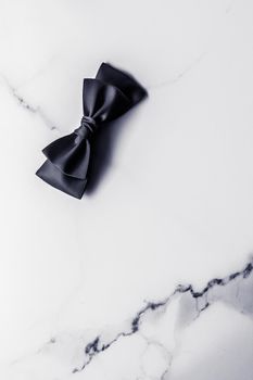 Holiday gift, decoration and sale promotion concept - Black silk ribbon and bow on marble background, flatlay