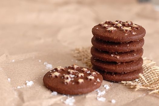 there is a stack of round chocolate christmas cookies with sugar stars and salt on brown craft paper