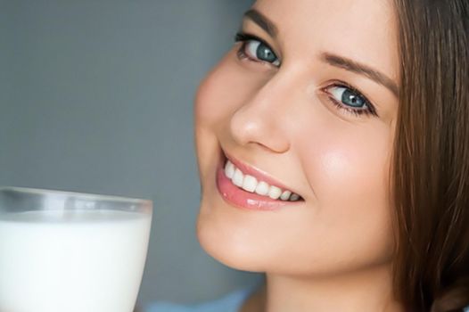 Diet and wellness, young woman with glass of milk or protein shake cocktail, portrait