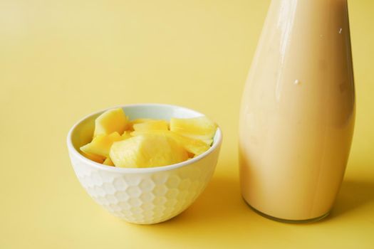 mango smoothie and fresh mango on yellow background ,