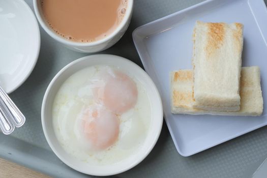 half boiled egg, toasted bread and tea on table ,