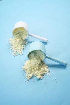 Close up of baby milk powder and spoon on tile background