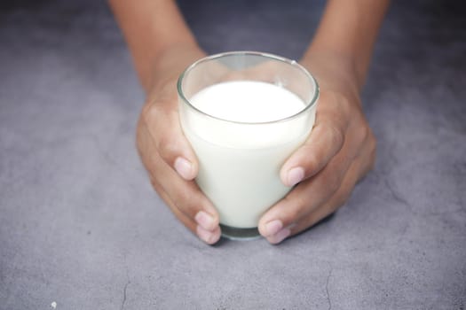 man hand holding glass of milk at early morning ,