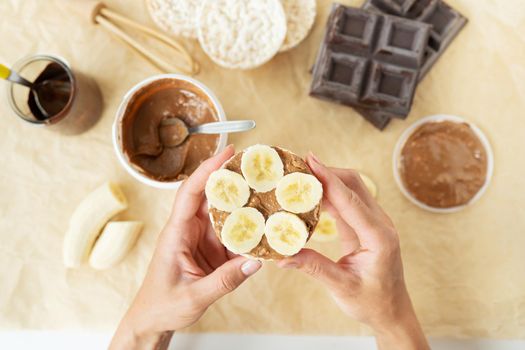 Top view of the process of preparing a delicious peanut butter dessert along with rice cakes and a banana. Vegan dessert, tasty and healthy