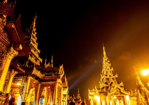 The Ghost Image and Lens Flare in the picture of group of golden pagodas and mondops are illuminated in the light of the night