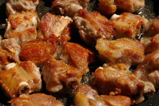 Close up Pork bone fried in a cooking pan with garlic