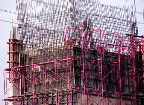 The pink scaffolding on the building under construction